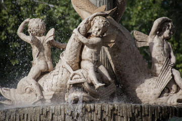 detalle de escultura de ángel con pez en la fuente de El Retiro