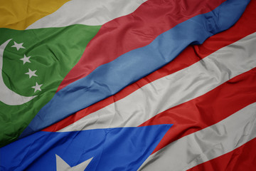 waving colorful flag of puerto rico and national flag of comoros.
