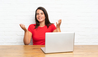 Young girl with pc in a table unhappy and frustrated with something