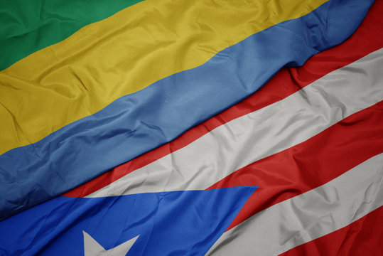 waving colorful flag of puerto rico and national flag of gabon.