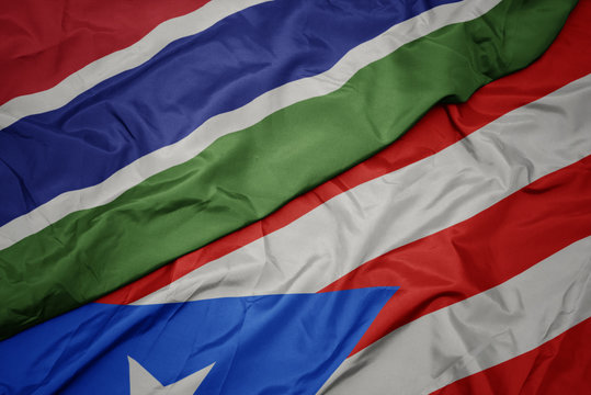 waving colorful flag of puerto rico and national flag of gambia.