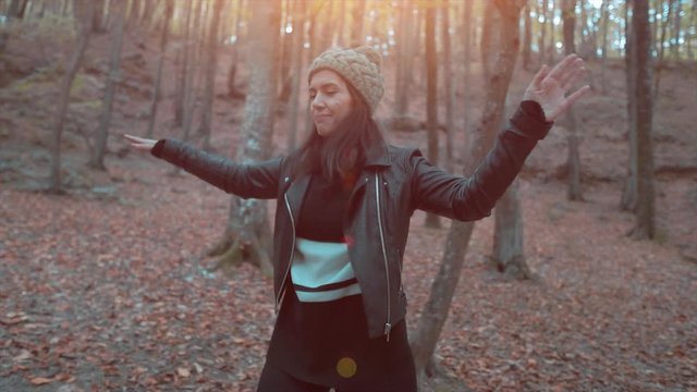 Beautiful young woman is dancing on forest in autumn time. Happy, joy footage, lifestyle and free time. Hiking and dance performance from cute girl. 