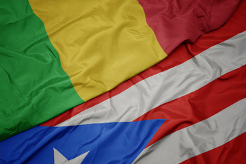 waving colorful flag of puerto rico and national flag of mali.