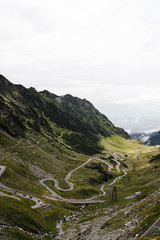 Endless road turns at the world famous mountain pass road Transfagarasan with clouds rolling in as seen during a Romania road trip (Romania, Europe)