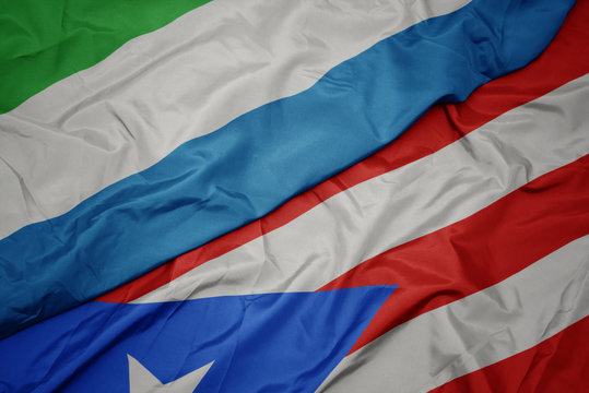 waving colorful flag of puerto rico and national flag of sierra leone.