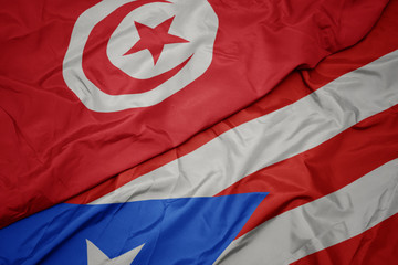 waving colorful flag of puerto rico and national flag of tunisia.