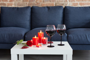 Romantic evening in red colores with wine, roses and candles.
