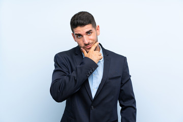 Handsome man over isolated blue background thinking