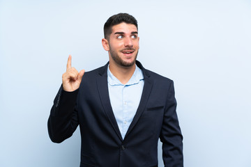 Handsome man over isolated blue background intending to realizes the solution while lifting a finger up