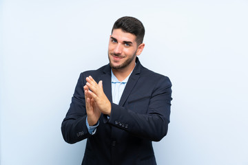 Handsome man over isolated blue background applauding after presentation in a conference