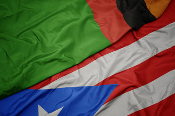 waving colorful flag of puerto rico and national flag of zambia.