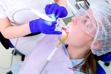 Patient woman visit dental hygienist on ultrasonic teeth cleaning procedure in dentistry, side...