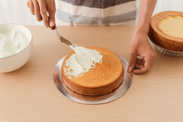 Spread the sponge cake with ice cream on wood table