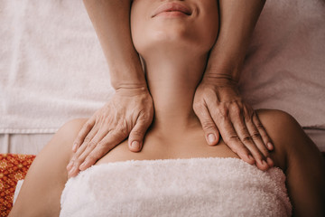 Obraz na płótnie Canvas cropped view of masseur doing neck massage to woman in spa salon