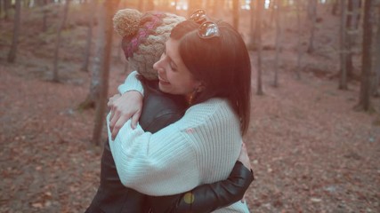 Best friend girls are hugging, and waving hand to camera. Positive, attractive woman and friendship concept. Happy people in holiday time. 