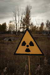 Yellow radioactive sign in the Chernobyl exclusion zone near the ghost town of Pripyat and the...