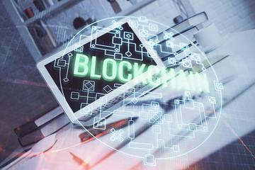 Multi exposure of blockchain theme hologram and table with computer background. Concept of bitcoin crypto currency.
