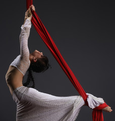 Young woman exercising on aerial cloth