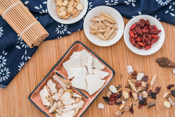 Various Chinese herbal medicines scattered on bamboo mats