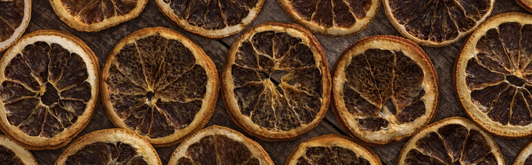 top view of dried orange slices on wooden background, panoramic shot