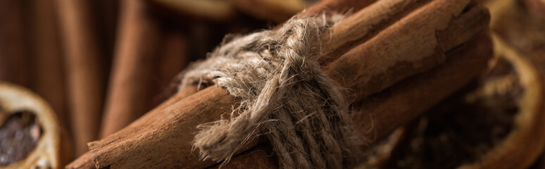 close up view of cinnamon bunch on dried citrus slices, panoramic shot