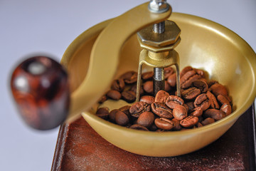 Details of coffee beans and a wooden grinder/mill. Vintage coffee mill isolated on white...