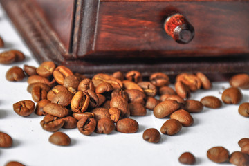 Details of coffee beans and a wooden grinder/mill. Vintage coffee mill isolated on white background. Manual coffee grinder. 