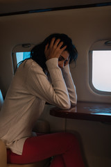 Fototapeta na wymiar scared woman with airsickness touching hair in private jet