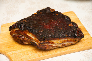 Large piece of fried pork, on a wooden platter