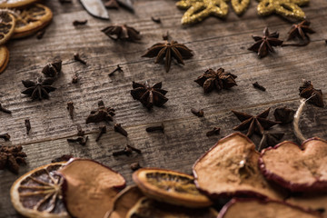 dried citrus and apple slices near anise on wooden surface