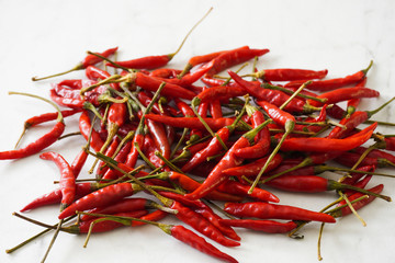 Fototapeta premium A pile of spicy Thai bird chiles on a marble cutting board