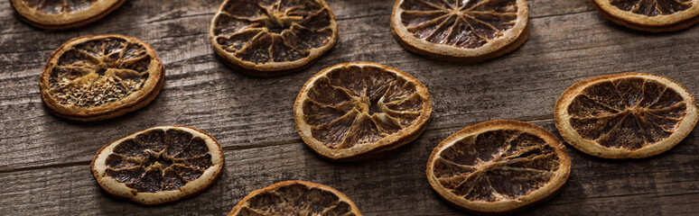 dried citrus slices on wooden brown surface, panoramic shot