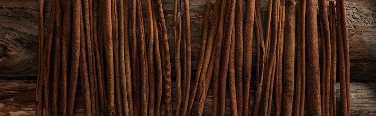 top view of cinnamon sticks on wooden background, panoramic shot