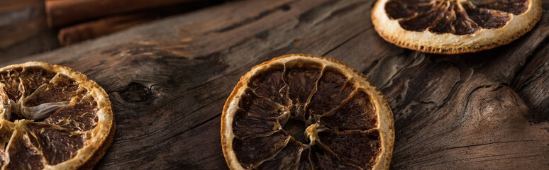 panoramic shot of dried citrus slices on wooden background