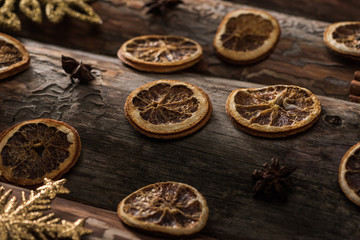 dried citrus slices with anise and decorative snowflakes on wooden background