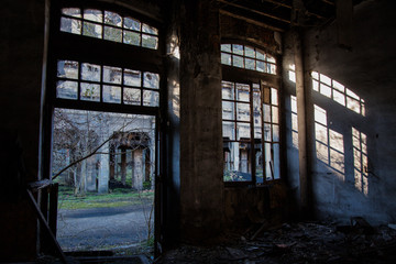 ventana en antigua fábrica abandonada por la que entra el sol