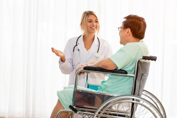 Obraz premium Doctor or Nurse help or assist or take care old patient while sitting on wheel chair in the hospital, elder care consulting concept