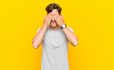  smiling and feeling happy, covering eyes with both hands and waiting for unbelievable surprise