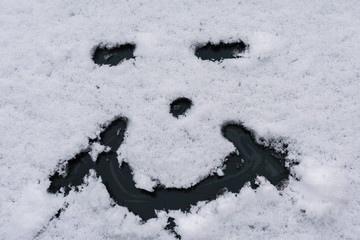Fototapeta premium Snow happy face on the car window. Winter concept