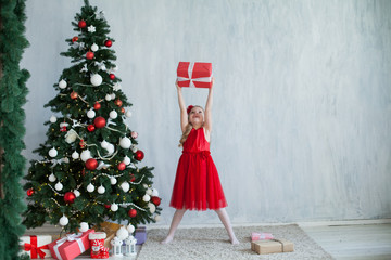 Little girl opens gifts at Christmas tree new year winter