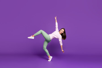 Full length body size side profile photo of cheerful beautiful attractive pretty sweet girl dancing like swan with hands spread balancing standing on one foot isolated purple vivid color background