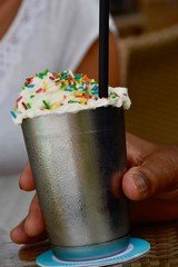  ice cold milkshake with whipped cream and colored sprinkles