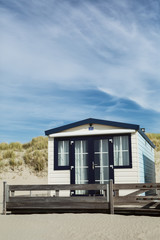 Fototapeta na wymiar Holiday House on a Beach with Dunes and a Blue Sky