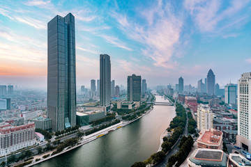 Fototapeta na wymiar Early morning scenery of the city skyscrapers along the Haihe River in Tianjin, China