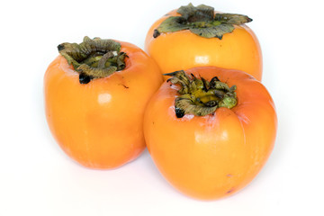 three persimmons on white background