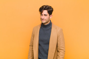 young handsome man looking happy and friendly, smiling and winking an eye at you with a positive...