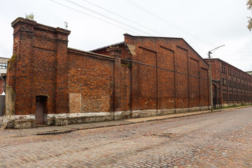 Stone-paved street and red brick building wall. Sovetsk, Kaliningrad region