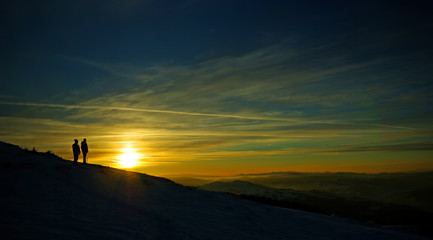 Fototapeta na wymiar People at sunset on the mountain