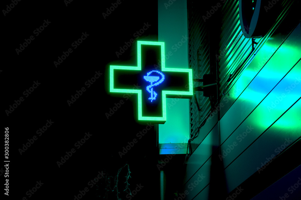 Wall mural health care medical store cross green sign symbol at front of the shop