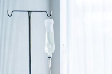 Normal saline bottle hanging from stand in hospital.  Health care and medical concept.